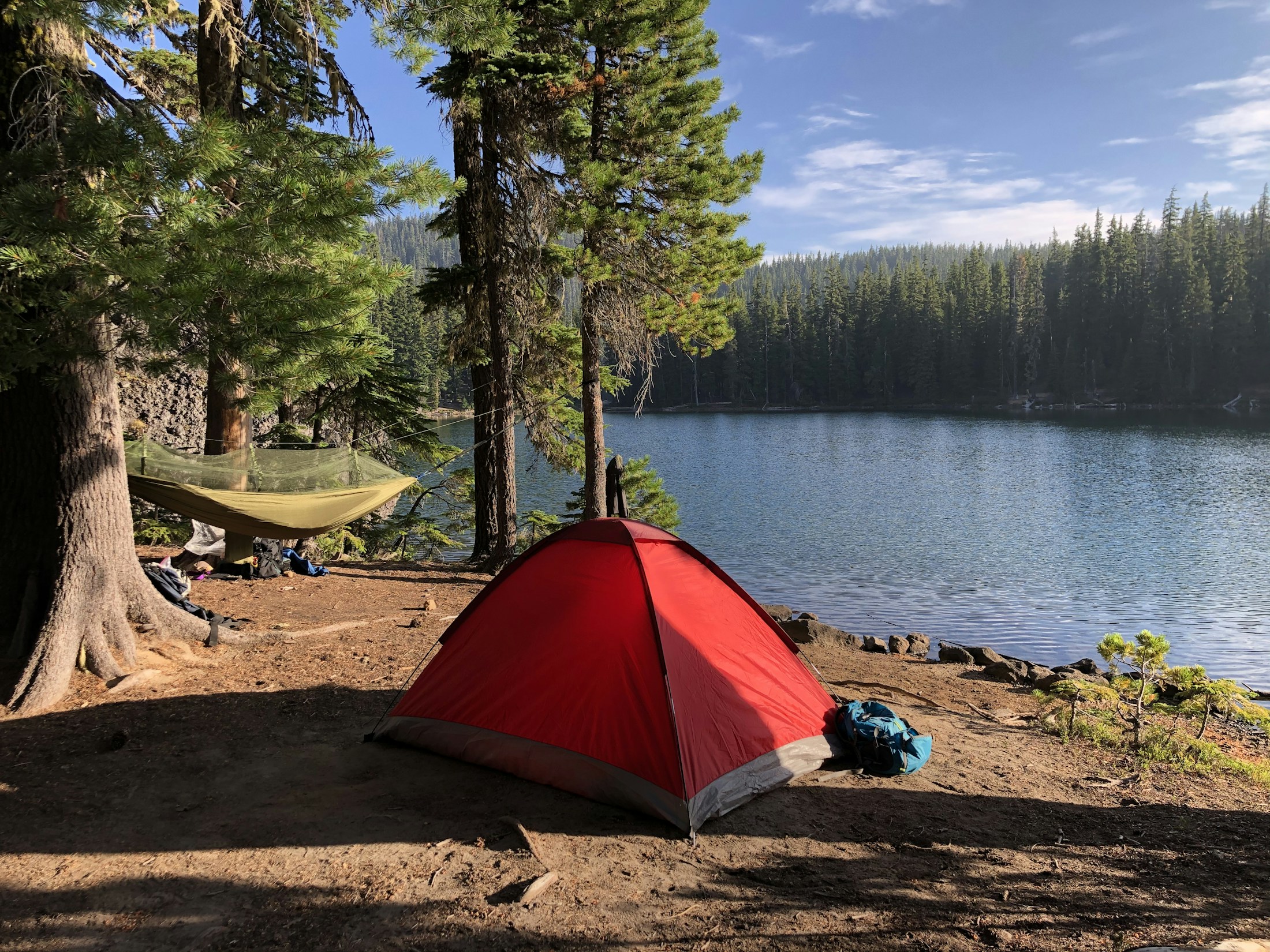 Zelt und Hängematte an einem Waldsee als Beispiel für einen Campingausflug